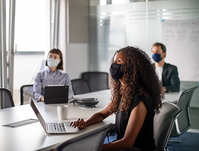 Small group gather in a conference room with masks on - Connections with our most engaged executives