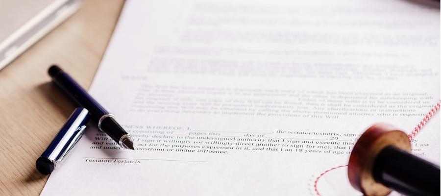 A pen and stamp on top of a legal contract